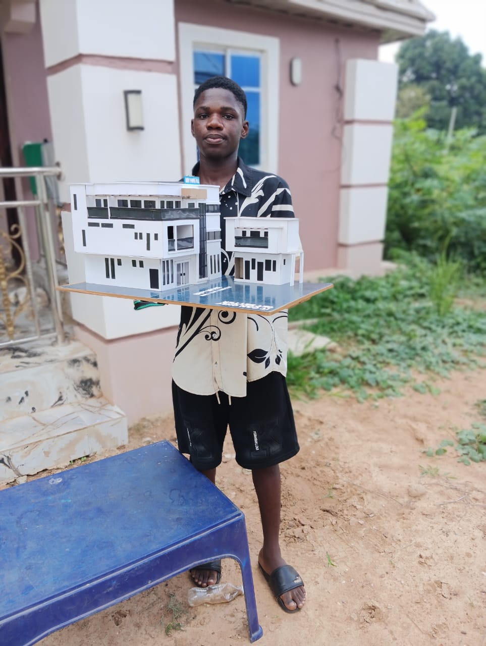 Chi Inventor (Chidubem), 18-year-old Nigerian inventor, holding one of his architectural models